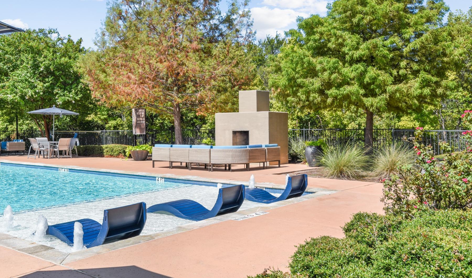 Settle into comfort at Waller Creekside on 51st a swimming pool with a bench and trees around it