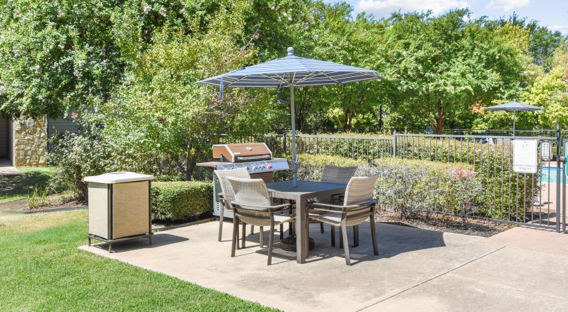 a patio with a table and chairs and umbrellas