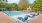 a swimming pool with trees and buildings around it