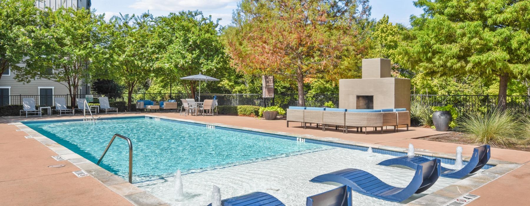 a swimming pool with trees and buildings around it