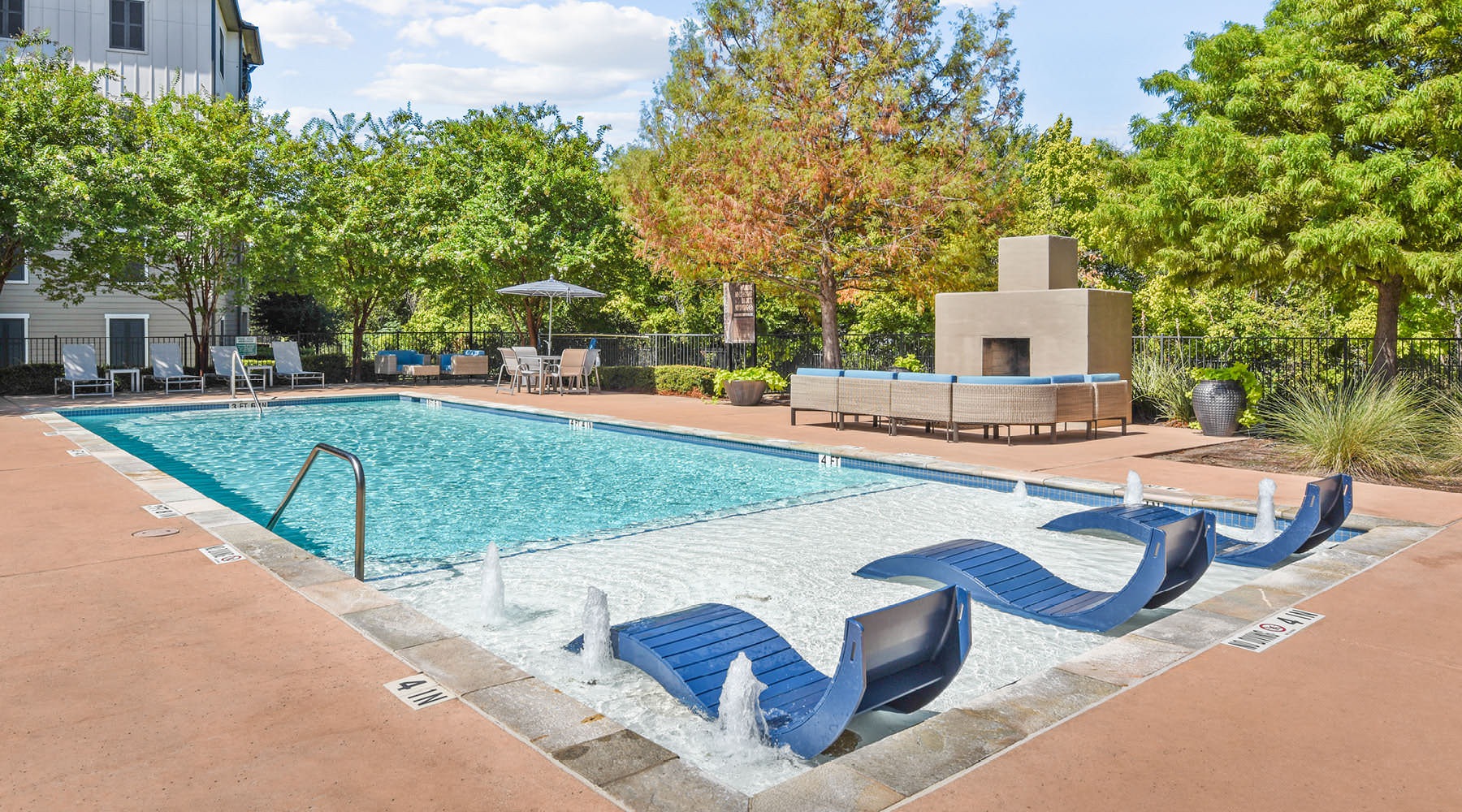 Resort-style swimming pool a swimming pool with trees and buildings around it