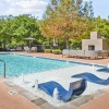 a swimming pool with trees and buildings around it